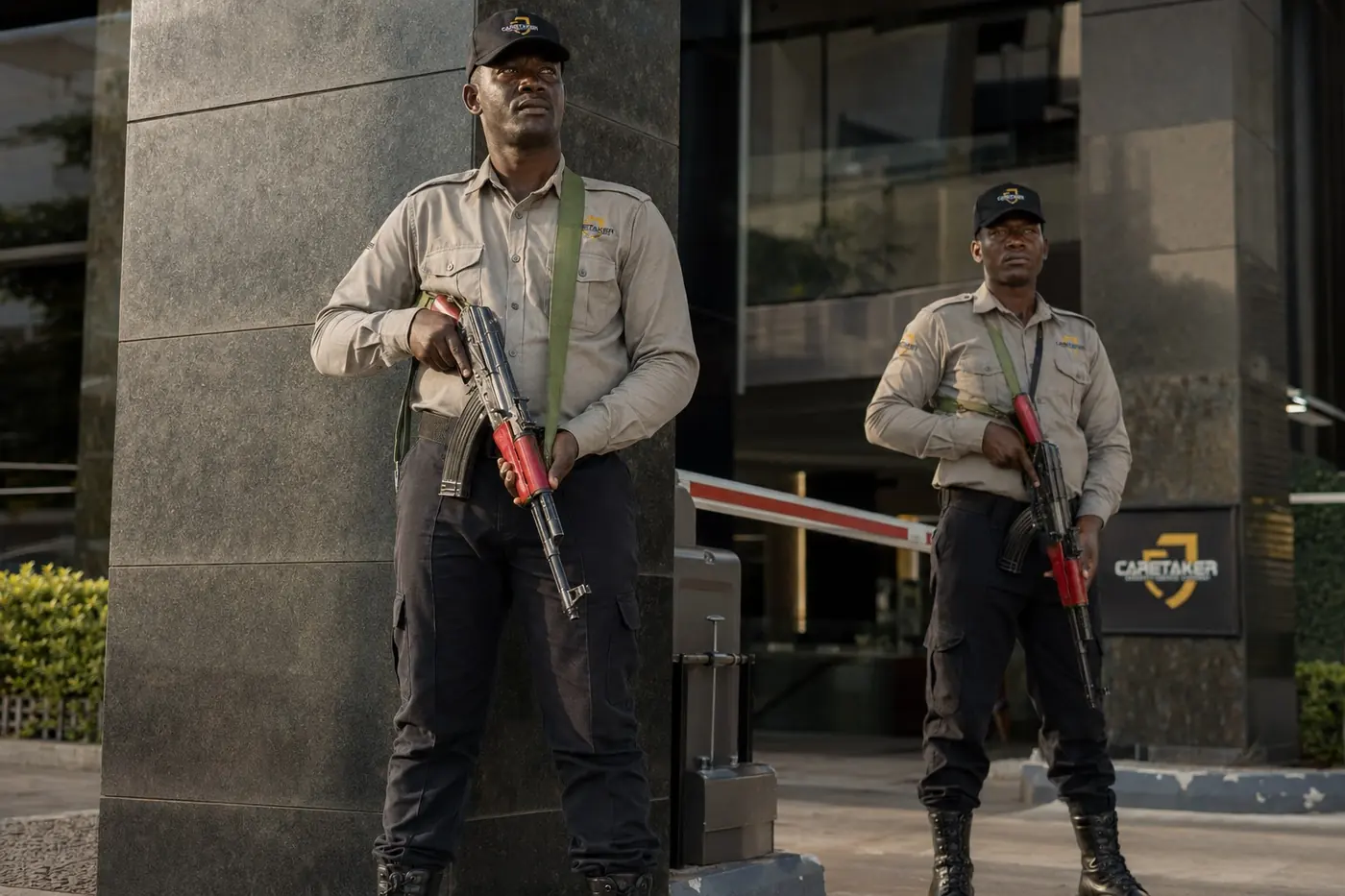 Caretaker officers on armed guard duty at a corporate entrance